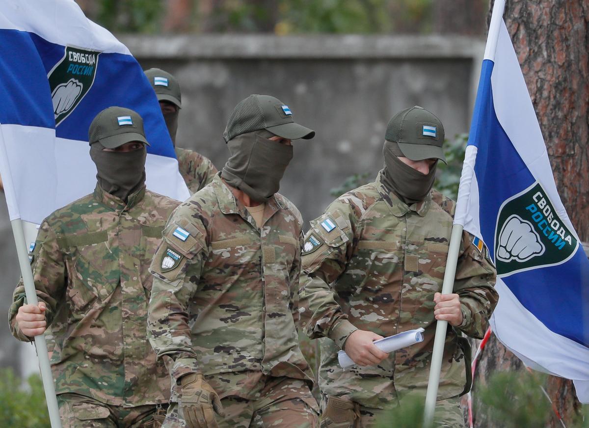 Members of the Freedom of Russia Legion carrying their flag walk through the city of Irpin near Kyiv, Ukraine, 31 August 2022. Photo: EPA-EFE / SERGEY DOLZHENKO