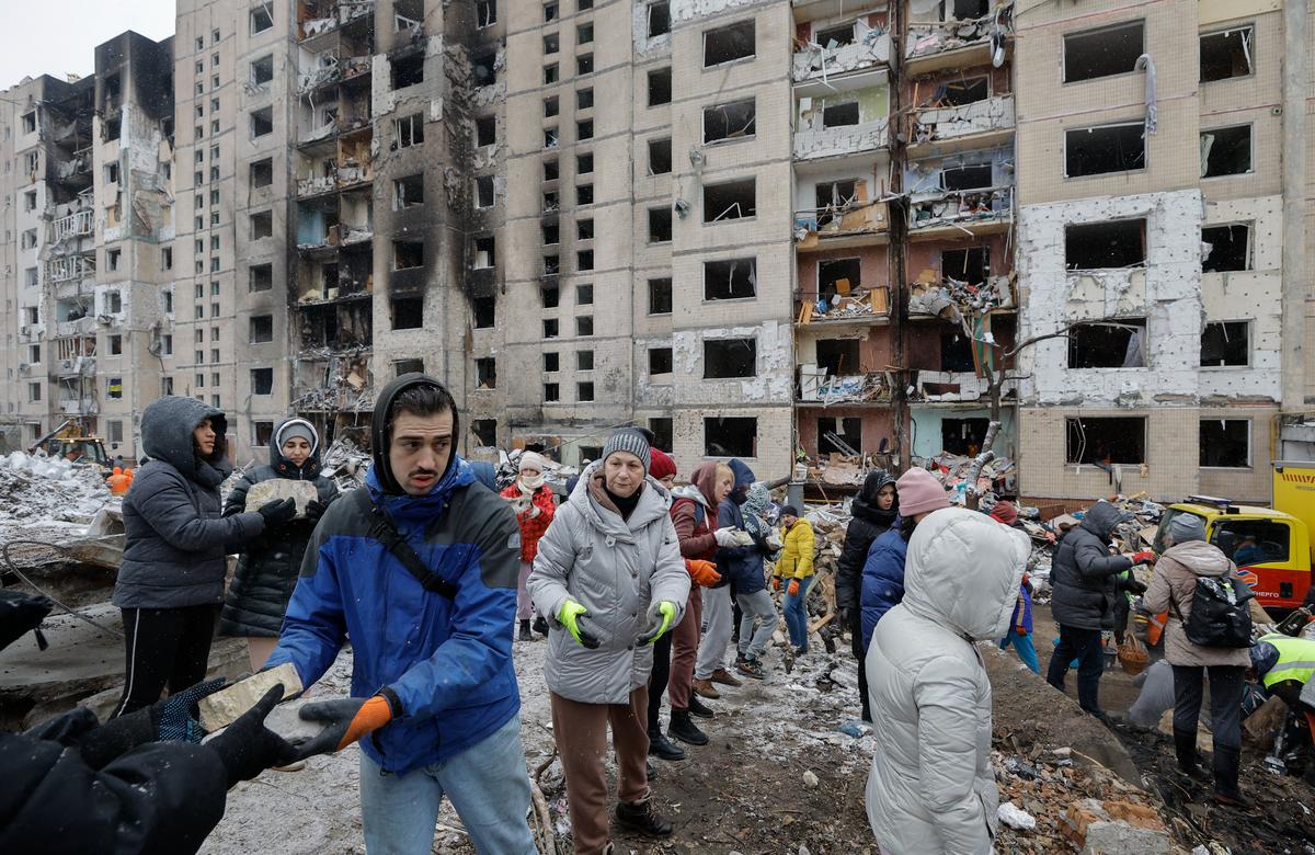 Волонтеры убирают обломки на месте поврежденного здания после ракетного удара в Киеве, 3 января 2024 года. Фото: Сергей Долженко / EPA-EFE