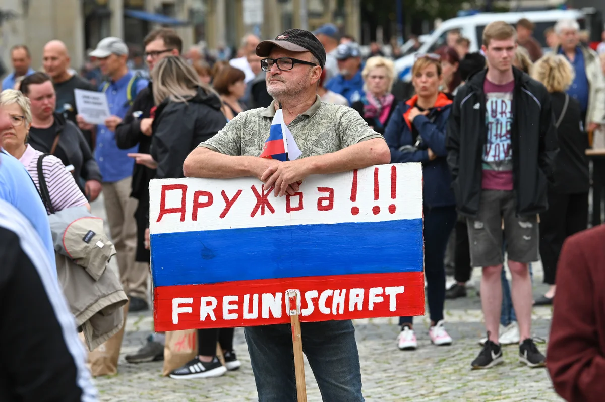 A participant in an AfD rally holds a Russian-colored poster with the word "Friendship," July 1, 2023. Photo: Heiko Rebsch / dpa / Picture-Alliance / Scanpix / LETA