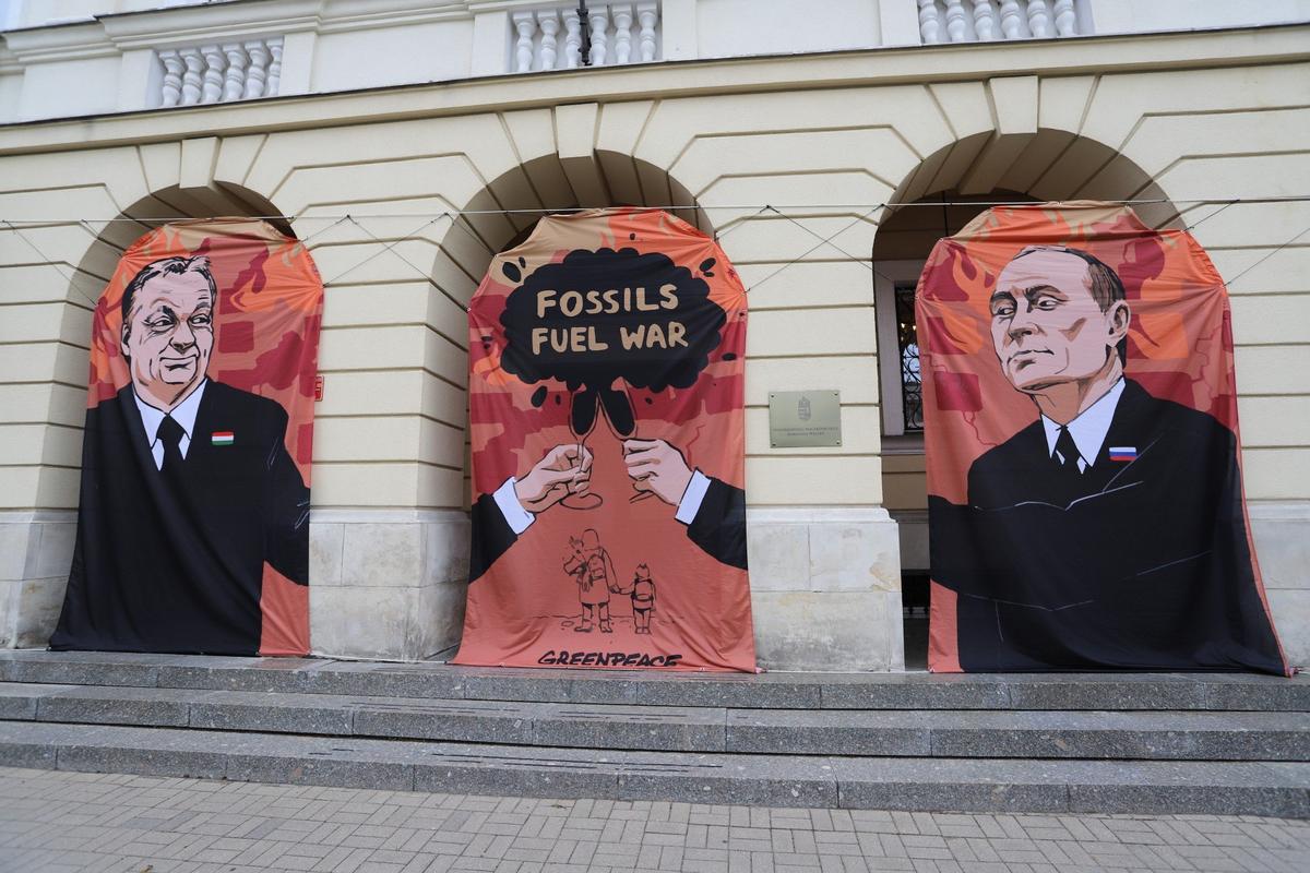 Баннер с изображением Виктора Орбана и Владимира Путина и лозунгом «Ископаемые — топливо войны» во время акции Greenpeace с требованием бойкота российской нефти перед посольством Венгрии в Варшаве, 25 мая 2022 года. Фото: 
EPA-EFE