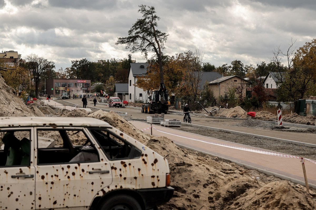 Рабочие восстанавливают дорогу, разрушенную в результате боевых действий в марте 2022 года, в городе Ирпень, 23 октября 2023 года. Фото: Олег Петрасюк / EPA-EFE