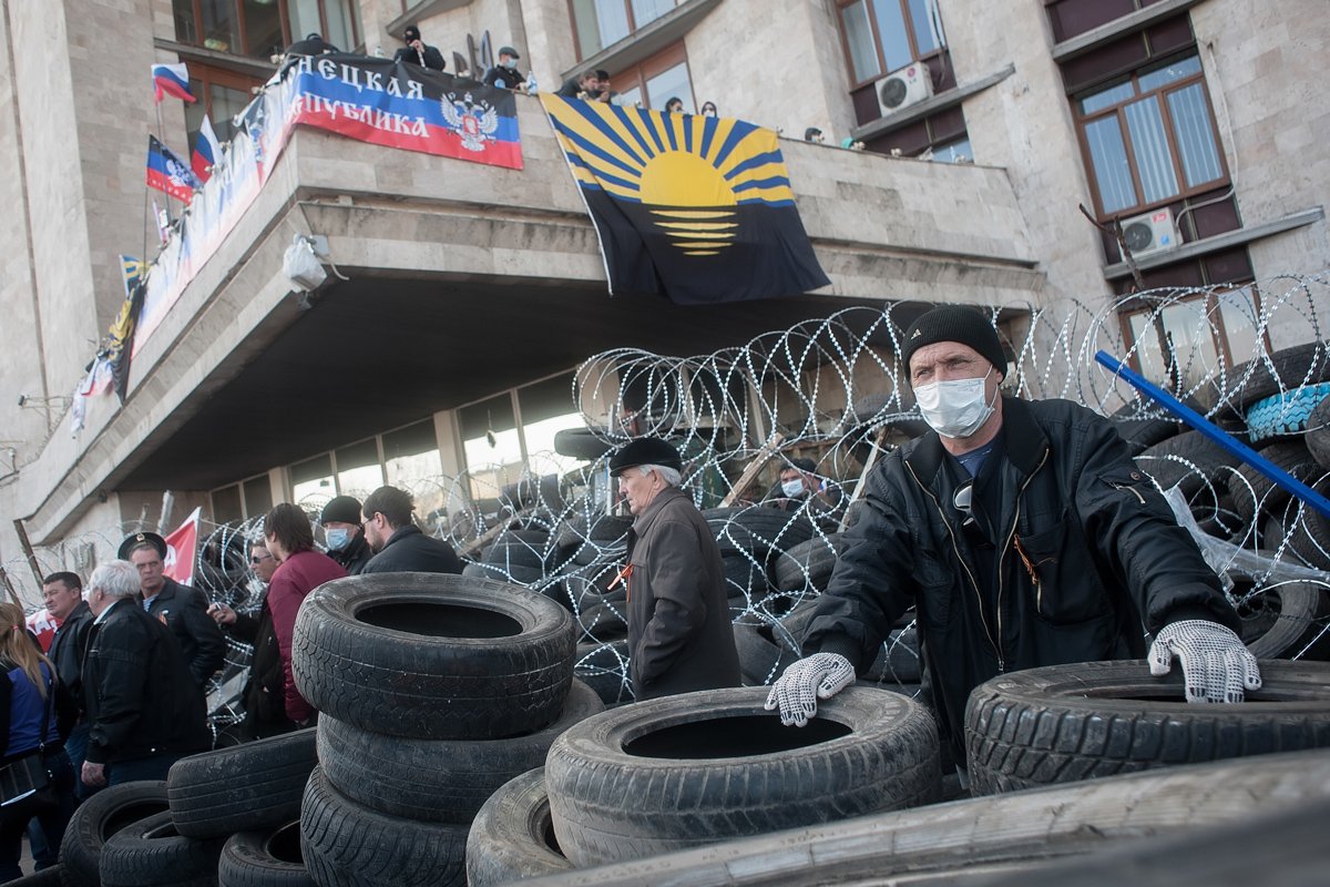 Пророссийские демонстранты собираются возле баррикады у занятого здания областной администрации в Донецке. Фото: Роман Пилипей / EPA