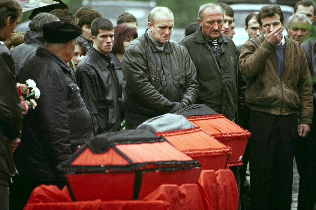 Скорбящие родственники стоят во время траурной церемонии на Хованском кладбище рядом с гробами жертв взрыва на Каширском шоссе, где погибли 118 человек. Фото: Stringer / EPA
