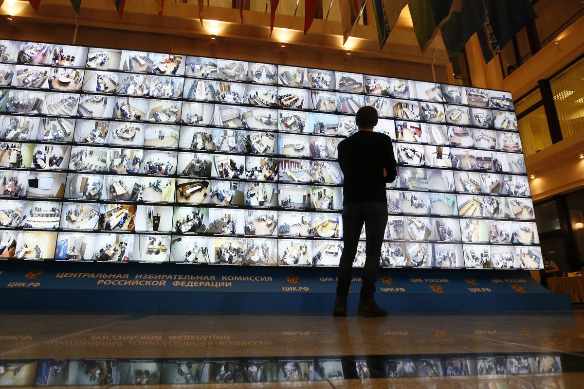 Мужчина смотрит на экран, показывающий прямую трансляцию с избирательных участков во время президентских выборов в штаб-квартире Центральной избирательной комиссии РФ в Москве, Россия, 18 марта 2018 года. Фото: Максим Шипенков / EPA-EFE