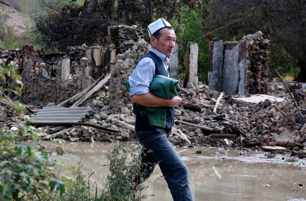 A Kyrgyz man inspects the damage on the Kyrgyz-Tajik border in the village of Kapchygay, 1000 km from Bishkek, Kyrgyzstan, on 21 September 2022. Photo: EPA-EFE / IGOR KOVALENKO
