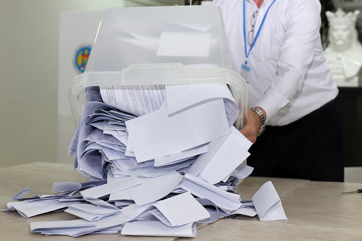 Një anëtar i komisionit zgjedhor zbraz një kuti votimi pasi qendra e votimit mbyllet në Kishinau, 20 tetor 2024. Foto: Reuters / Scanpix / LETA