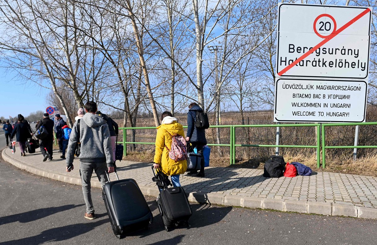 Украинцы пересекают венгерскую границу после начала полномасштабного вторжения России недалеко от города Берегово в Закарпатской области, 25 февраля 2022 года. Фото: Attila Kisbenedek / AFP / Scanpix / LETA