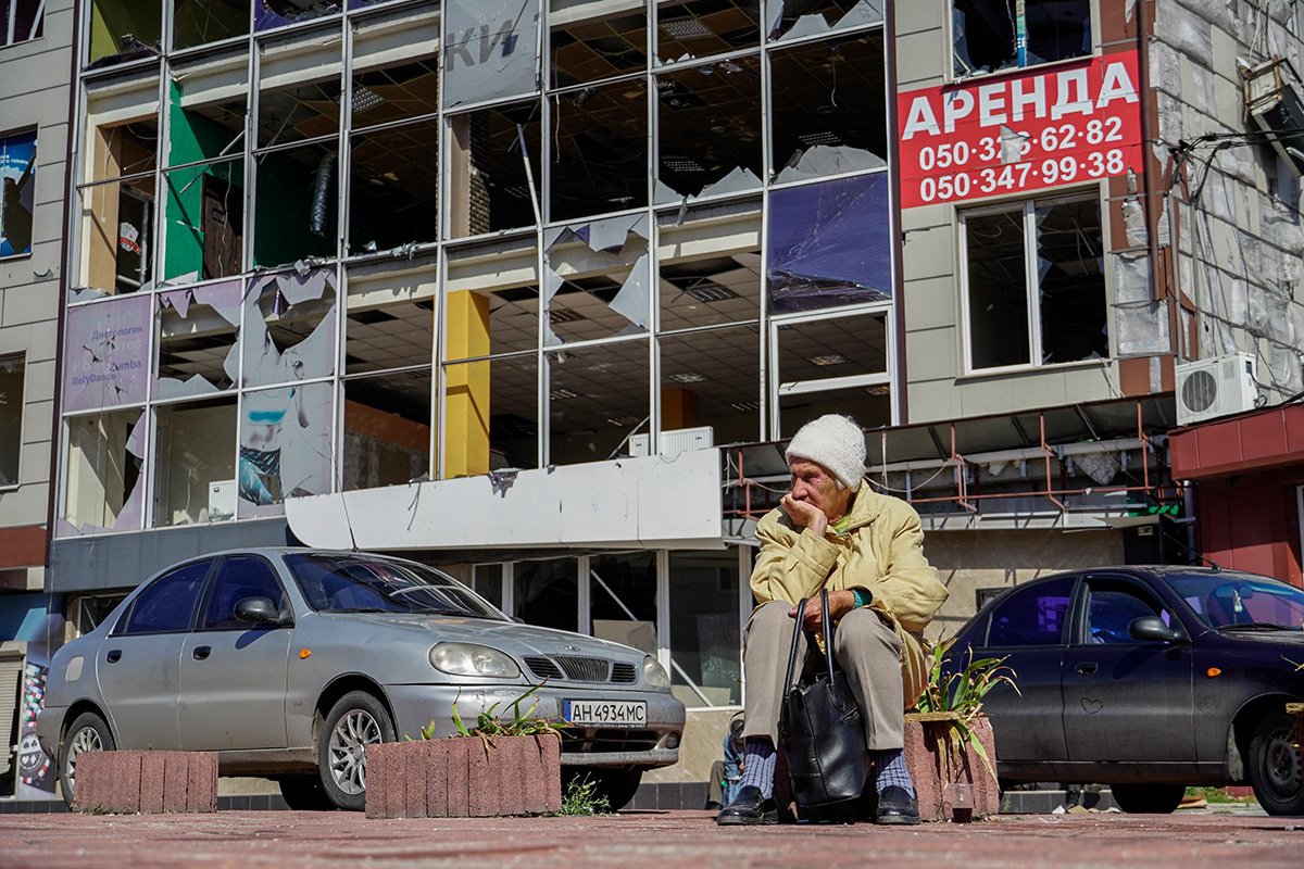 Пожилая женщина ждет раздачи горячей еды на фоне разрушенного здания, Мариуполь, Украина, 25 сентября 2022 года. Фото: Stringer / EPA-EFE