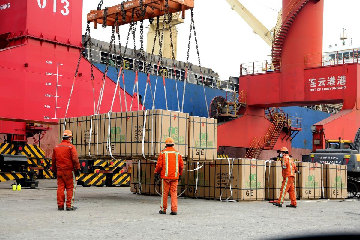Рабочие загружают и разгружают импортные и экспортные грузы в порту Ляньюньган, провинция Цзянсу, Китай. Фото: CFOTO / Future Publishing / Getty Images