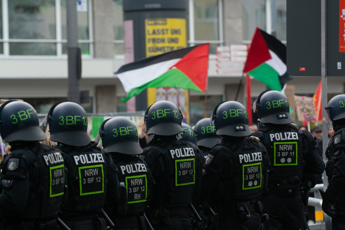 Полицейские наблюдают за тем, сторонники Палестины собираются на противоположной стороне Домской соборной площади в Кельне, Германия, 12 ноября 2023 года. Фото: Ying Tang / NurPhoto / Getty Images