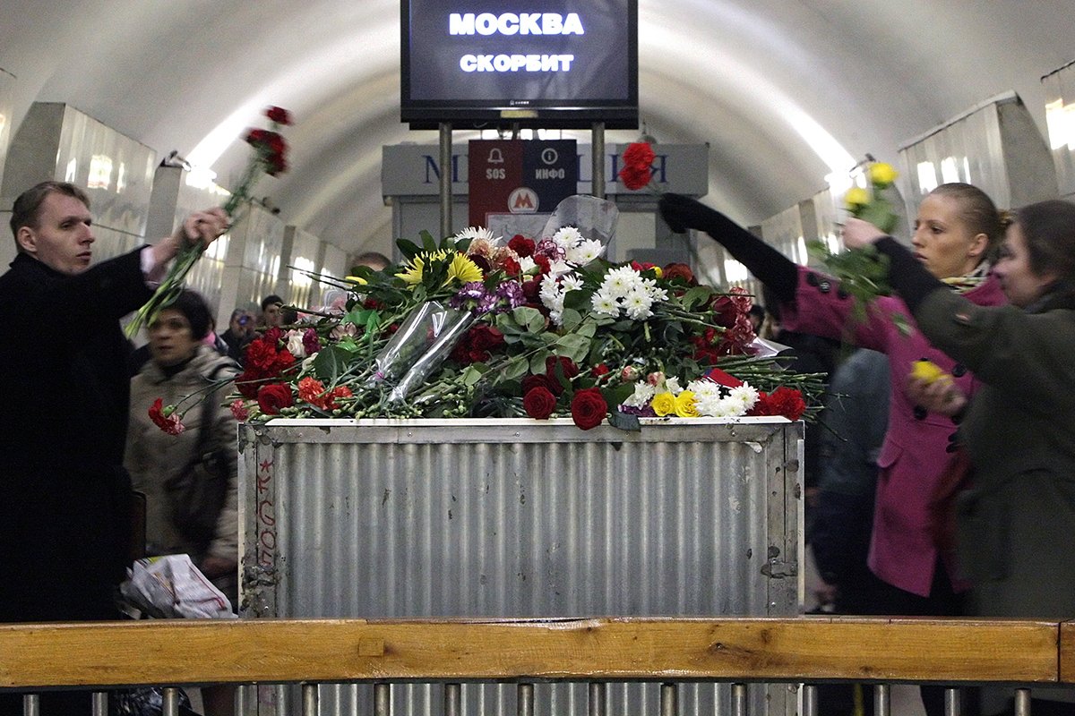 Внутри станции метро «Лубянка» в Москве пассажиры возлагают цветы в память о жертвах взрыва. В результате двух взрывов на станциях метро «Лубянка» и «Парк культуры» утром 29 марта погибли 40 человек и несколько десятков получили ранения. Фото: Максим Шипенков/EPA