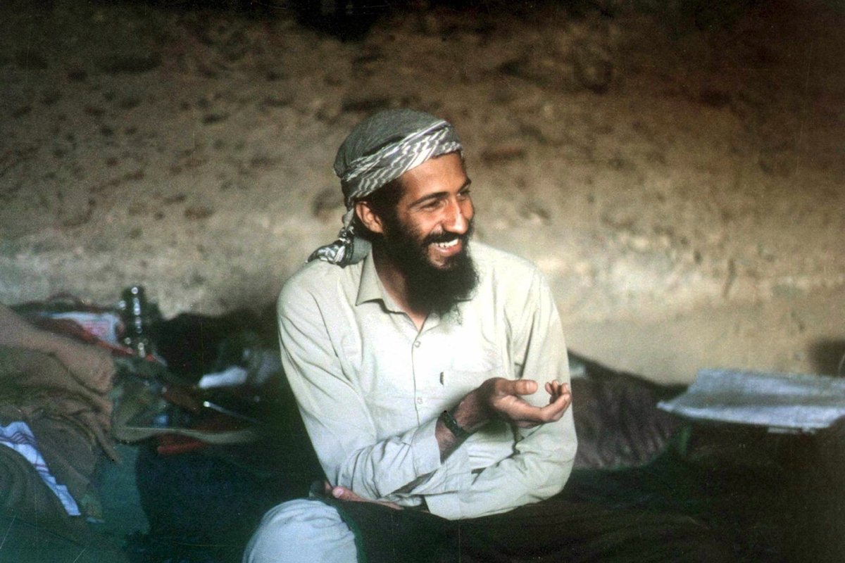 Усама бен Ладен улыбается, сидя в пещере в районе Джелалабад в Афганистане, 1988 год. Фото: Stringer / EPA