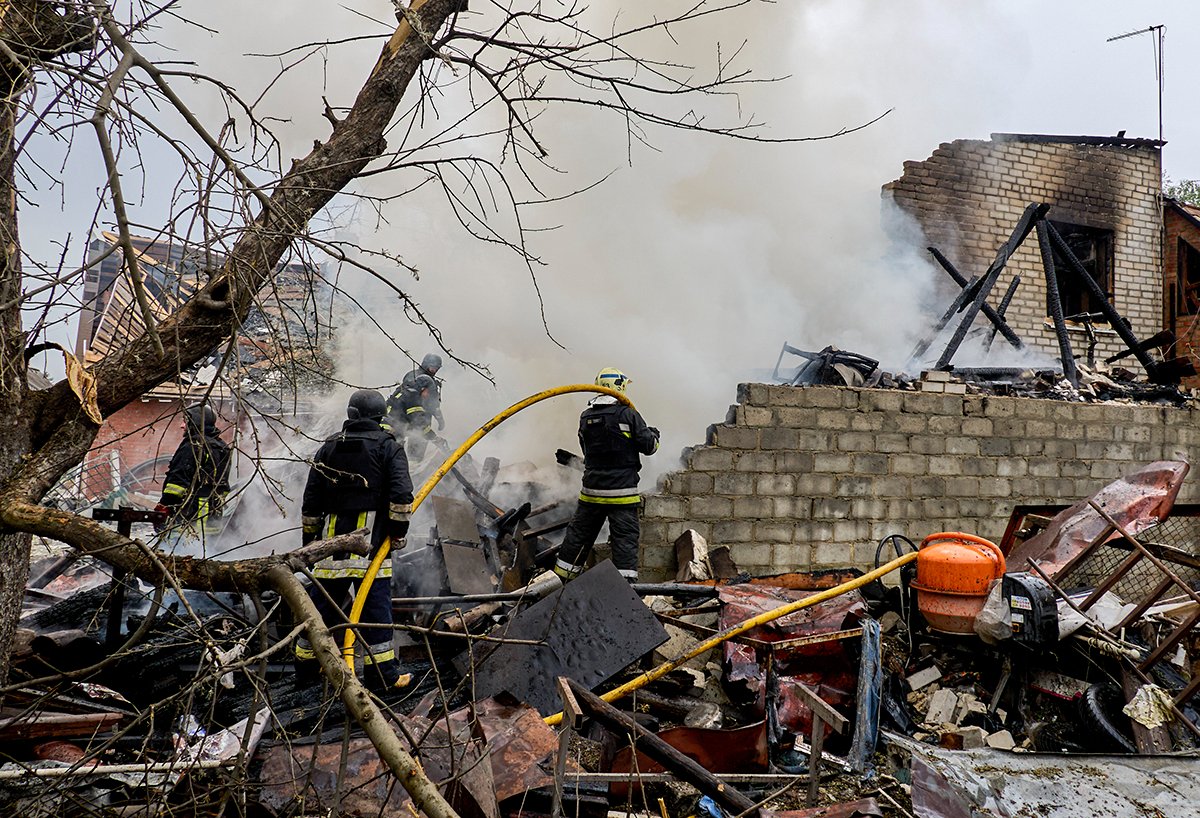 Украинские спасатели работают на месте после того, как в частный дом попал снаряд, Дергачи Харьковской области, на северо-востоке Украины, 26 апреля 2024. Фото: Сергей Козлов / EPA-EFE