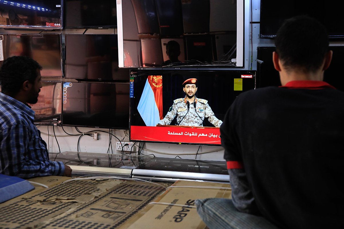 Жители Саны (Йемен) смотрят телевизионное заявление военного представителя хути Яхьи Сареа после ракетной атаки йеменских хути, 10 января 2024 года. Фото: Yahya Arhab / EPA-EFE