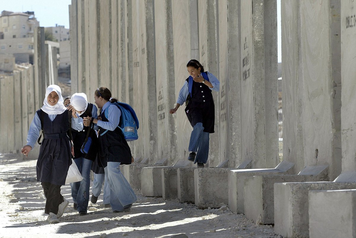 Палестинские школьницы возле израильской стены безопасности, проходящей через деревню Савахрех на Западном берегу, отделяя ее от Восточного Иерусалима. 25 сентября 2003 года, Фото: David Silverman / Getty Images