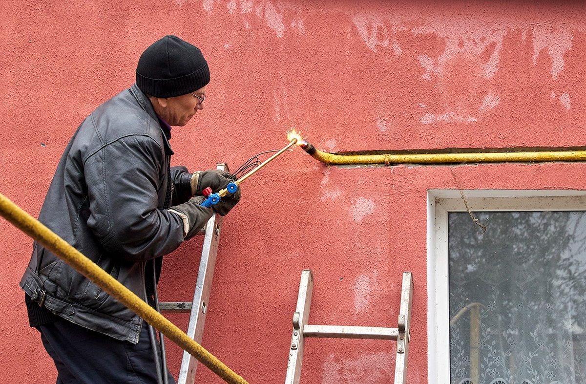 Коммунальщики ремонтируют газовую трубу в попытке подготовить частный дом к зиме в селе Русские Тишки Харьковской области, Украина, 5 октября 2022 года. Фото: Сергей Козлов / EPA-EFE