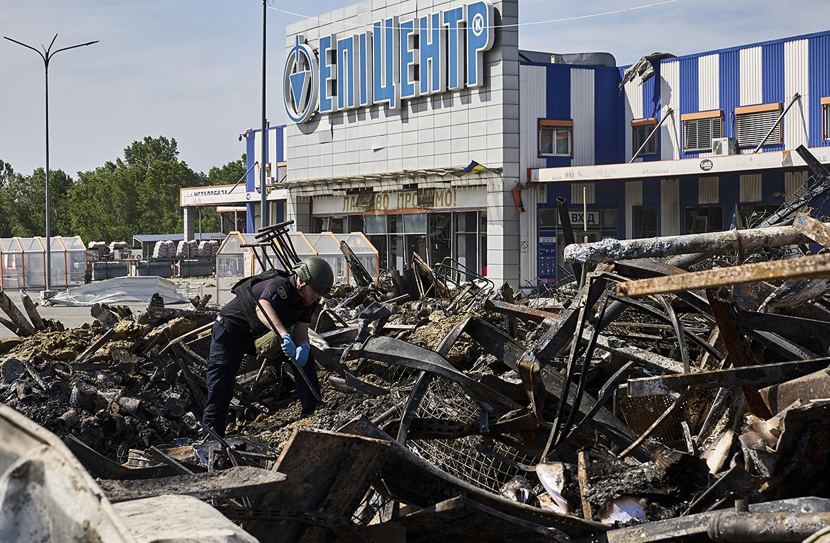 Полицейский осматривает поврежденные конструкции после обстрела гипермаркета в Харькове, Украина, 26 мая 2024 года. Фото: Сергей Козлов / EPA-EFE