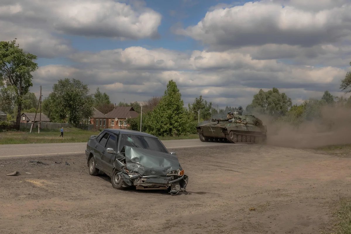 A Ukrainian howitzer drives past a damaged car on the road to Vovchansk, 12 May, 2024. Photo: Roman Pilipey /AFP / Scanpix