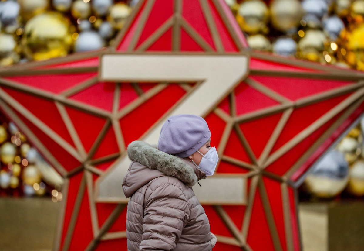 Прохожая идет мимо инсталляции с красной звездой с изображением буквы «Z» в Москве, 20 декабря 2023 года. Фото: Юрий Кочетков / EPA-EFE