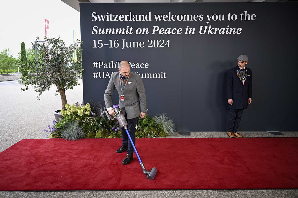 Уборка красной ковровой дорожки во время саммита по вопросам мира в Украине в Станстаде близ Люцерна, Швейцария, 15 июня 2024 года. Фото: Urs Flueeler / EPA-EFE
