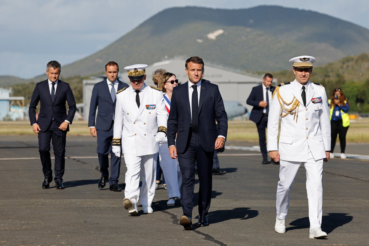 Президент Франции Эммануэль Макрон (в центре) с Верховным комиссаром Франции в Новой Каледонии Луи Ле Франком (третий слева) в международном аэропорту Нумеа, Новая Каледония, 23 мая 2024 года. Фото: Ludovic Marin / EPA-EFE