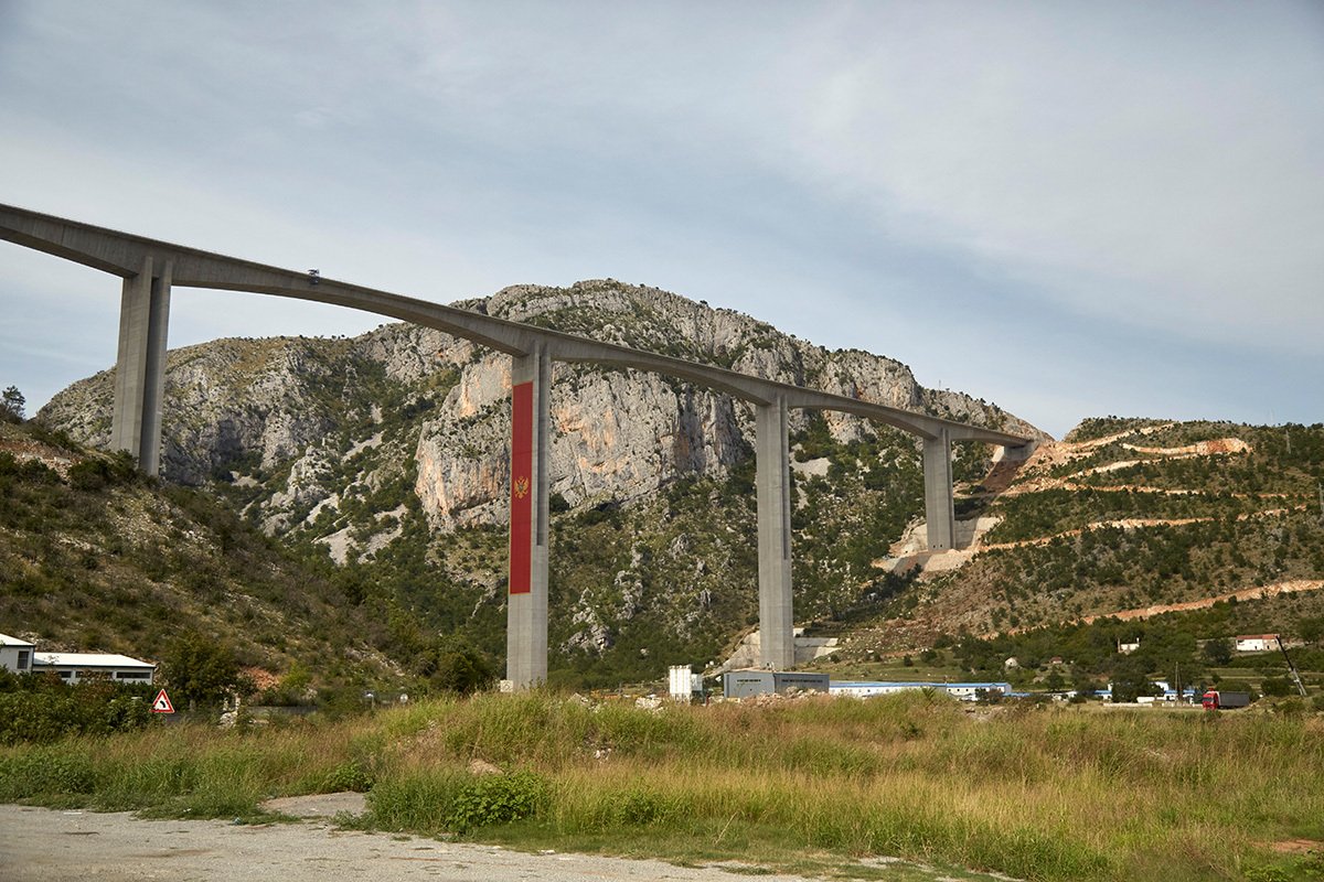 Большой черногорский флаг на строящемся мосту, являющемся частью финансируемой Китаем автомагистрали от Белграда в город Бар, сентябрь 2020 года. Фото: Pierre Crom / Getty Images