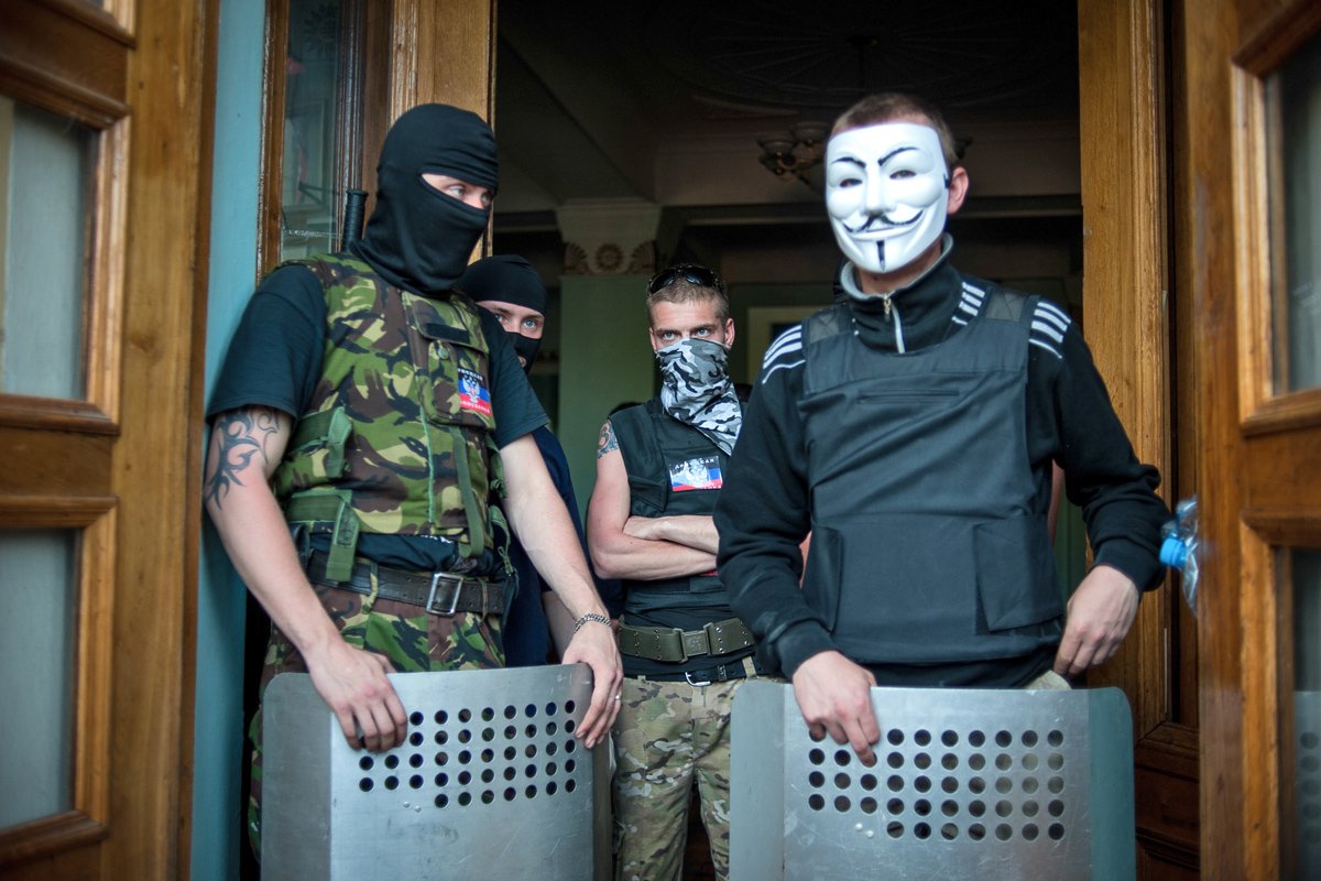 Пророссийские демонстранты охраняют входную дверь после захвата регионального телецентра в Донецке, 27 апреля 2014 года. Фото: Роман Пилипей / EPA