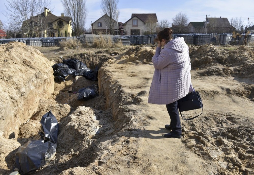 A woman stands near a mass grave in Bucha in April 2022. Photo: EPA-EFE/OLEG PETRASYUK