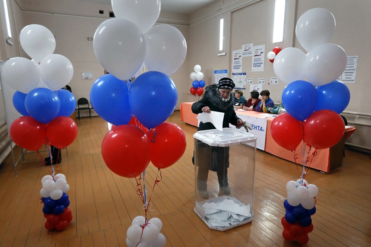 Женщина голосует на избирательном участке во время президентских выборов в Калужской области, Россия, 18 марта 2018 года. Фото: Юрий Кочетков / EPA-EFE