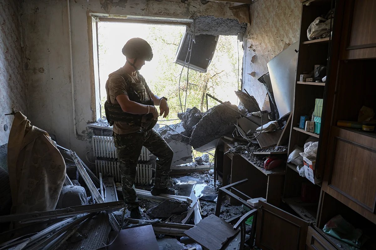 A Russian soldier examines damage caused by shelling in a residential building in the centre of Donetsk, Ukraine, 16 August 2024. Photo: Alessandro / Guerra / EPA