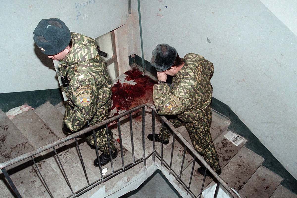 Два сотрудника милиции на лестнице в доме, где было совершено покушение на депутата Государственной Думы РФ Галину Старовойтову, 21 ноября 1998 года. Фото: Анатолий Мальцев / yk / hh / ow / EPA Photo