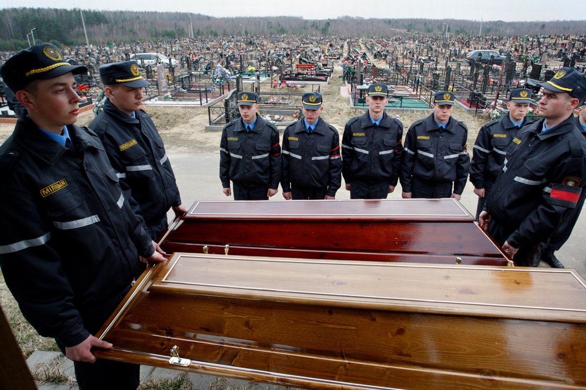 Белорусские милиционеры держат крышки гробов жертв взрыва во время траурной церемонии на кладбище на окраине Минска, 13 апреля 2011 года. Фото: Татьяна Зенькович / EPA