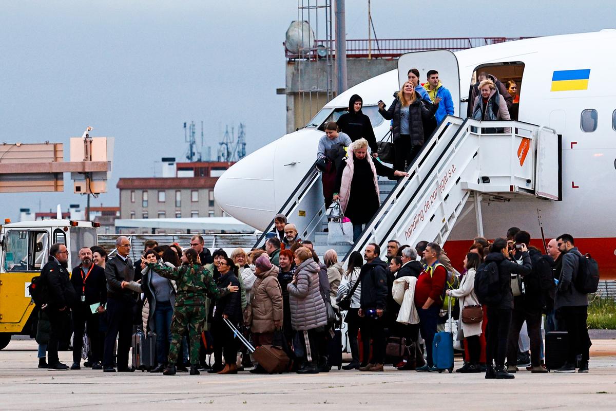A group of 170 Ukrainian refugees exiting an aeroplane after a flight from Moldova. Figo Maduro military aerodrome, Lisbon, Portugal, 22 December 2022. Photo: EPA-EFE/ANTONIO PEDRO SANTOS