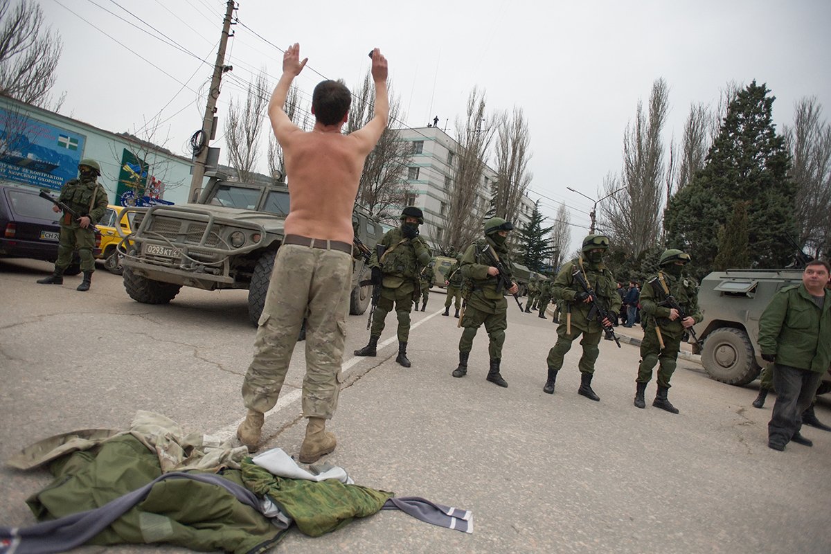 Мужчина просит уйти российских солдат, блокирующих украинскую военную базу в Балаклаве, Крым, Украина, 1 марта 2014 года. Фото: Антон Педько / EPA