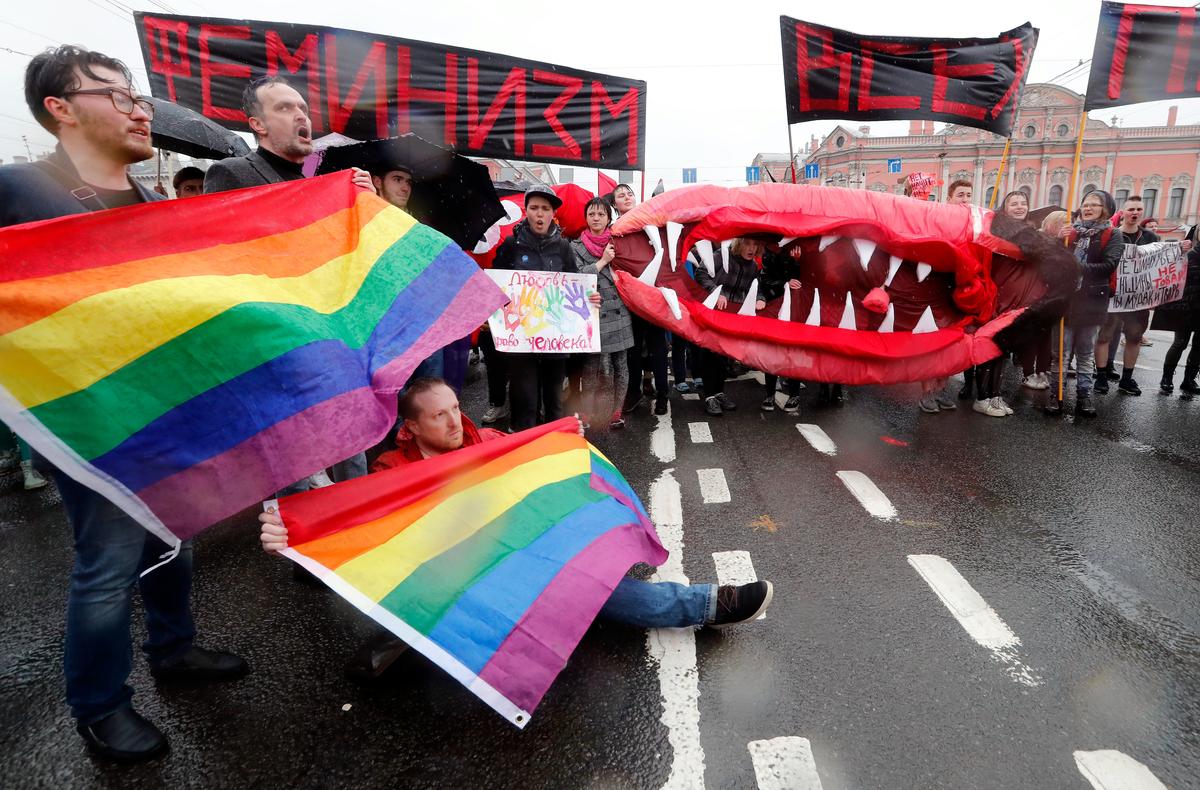 Активисты ЛГБТ-сообщества с радужными флагами и феминистки со своим символом принимают участие в митинге в честь Дня труда в Санкт-Петербурге, 1 мая 2018 года. Фото: Анатолий Мальцев / EPA-EFE