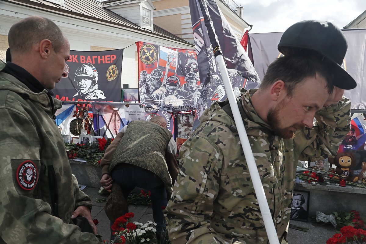 Мужчины в военной форме отдают дань памяти покойному Евгению Пригожину возле неофициального мемориала на 40-й день со дня его смерти, недалеко от Кремля в Москве, 1 октября 2023 года. Фото: Максим Шипенков / EPA-EFE