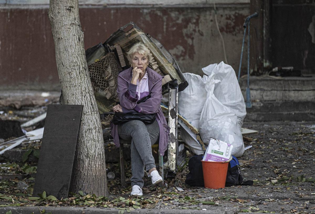 Женщина во дворе разрушенного дома в Запорожье, октябрь 2022 года. Фото: Metin Aktas / Anadolu Agency / Getty Images