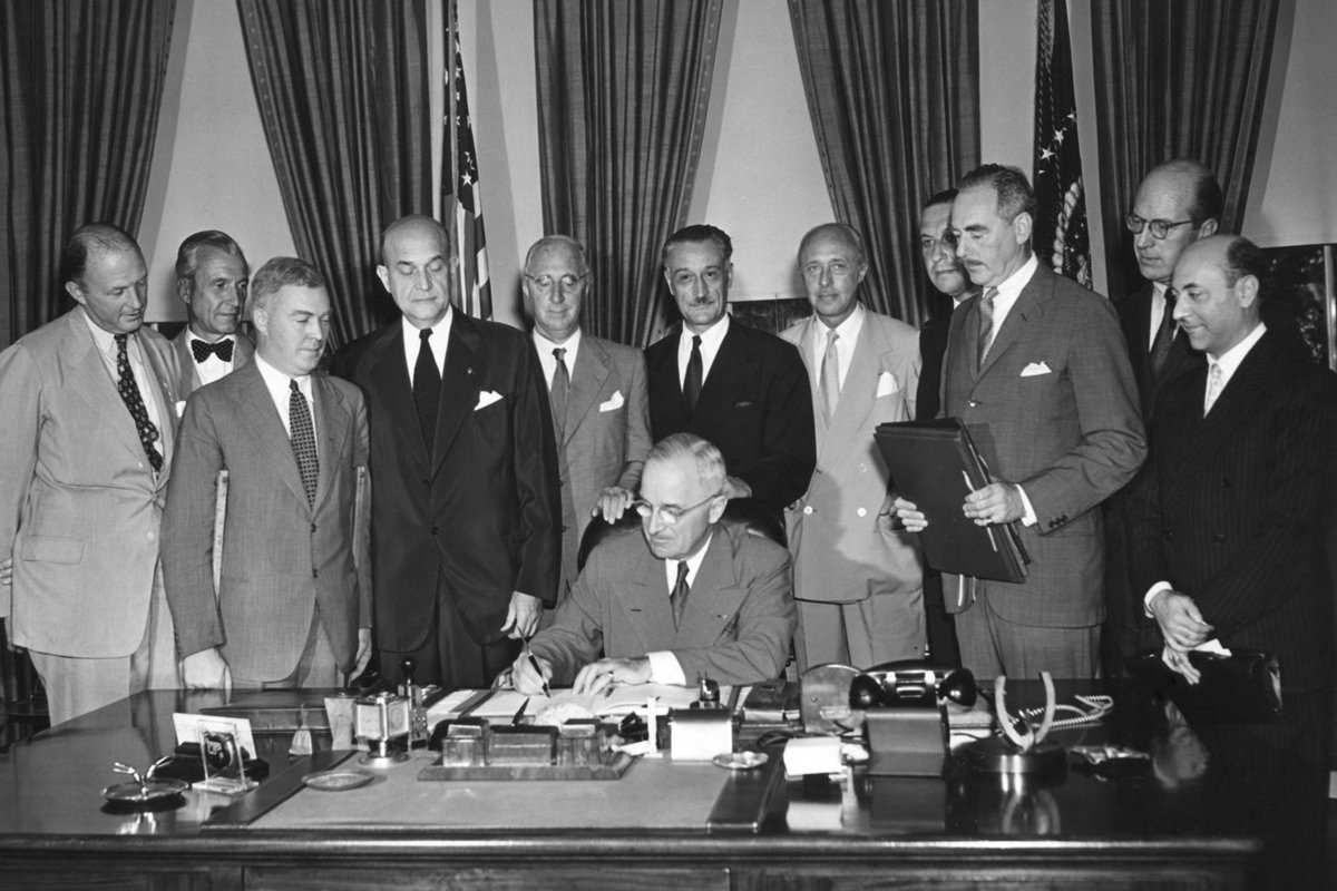 Президент Гарри Трумэн подписывает Североатлантический пакт, 24 августа 1949 года. Вокруг него дипломаты стран-подписантов и американские официальные лица, ставшие свидетелями этого подписания. Фото: Everett Collection / Vida Press