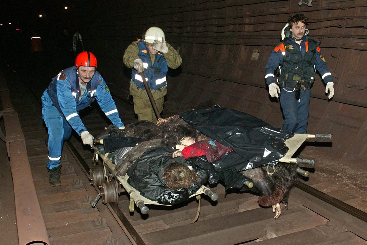 Спасатели везут вагонетку с телами жертв взрыва бомбы в московском метро, 6 февраля 2004 года. Фото: Stringer/EPA