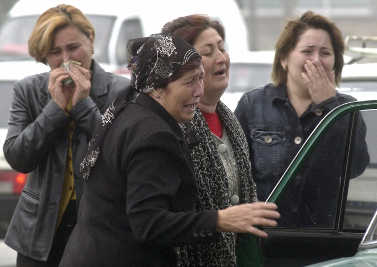 Женщины, чьи родственники оказались в заложниках у боевиков, плачут во время штурма здания магазина в городе Нальчик, 14 октября 2005 года. Фото: Stringer / EPA