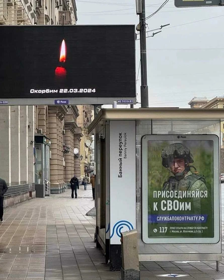 A Moscow billboard honouring those killed in Friday’s terror attack next to another promoting military enlistment. Photo: social media
