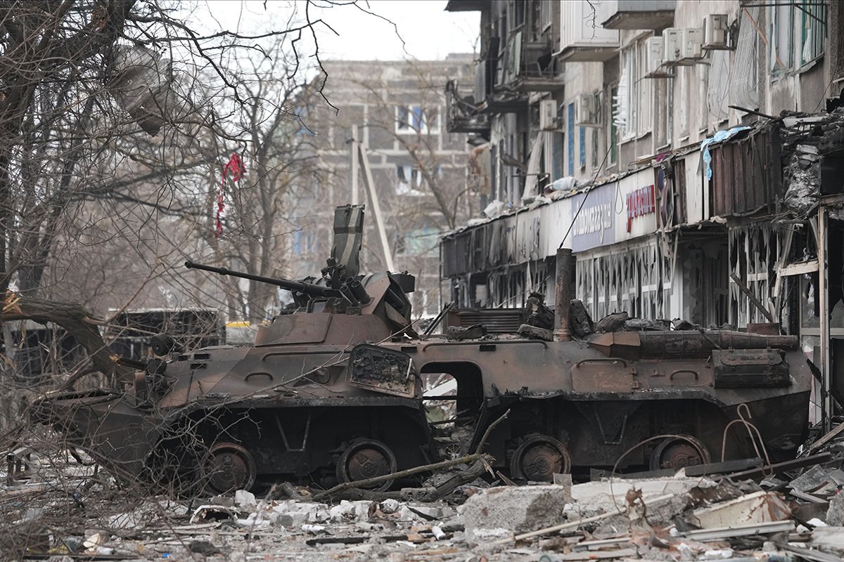 Разбитый танк рядом с поврежденным жилым домом в Мариуполе, Украина, 26 марта 2022 года. Фото: Stringer / Anadolu Agency / Getty Images