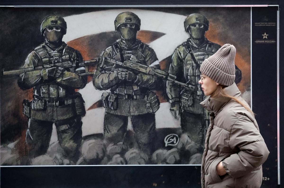 A woman walks past a Russian army poster in St. Petersburg, Russia, 30 November 2024. Photo: EPA-EFE/ANATOLY MALTSEV