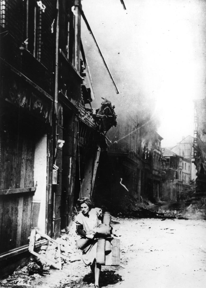 Женщина выходит из своего горящего дома на разбомбленной улице, Германия, 1945 год. Фото: Art Media/Print Collector/Getty Images
