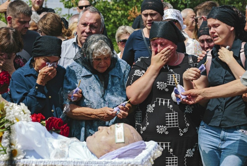 Mourners attend the funeral ceremony of Andriy Krasyuk, one of those killed in the Russian missile strike on the Amstor shopping mall in Kremenchuk, Ukraine, 30 June 2022. EPA-EFE/PAVLO PAKHOMENKO