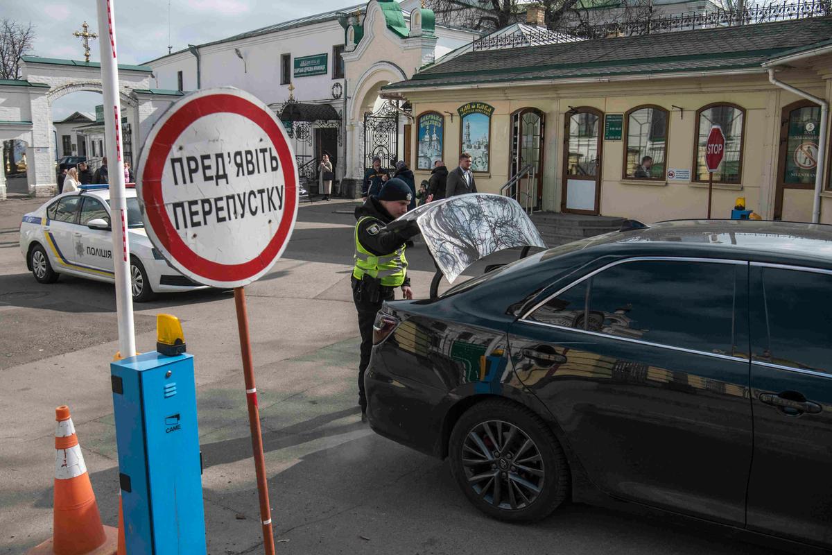 Полицеский досматривает автомобиль на въезде в Киево-Печерскую лавру, 19 марта 2023 года. Фото: Maxym Marusenko / NurPhoto / Getty Images