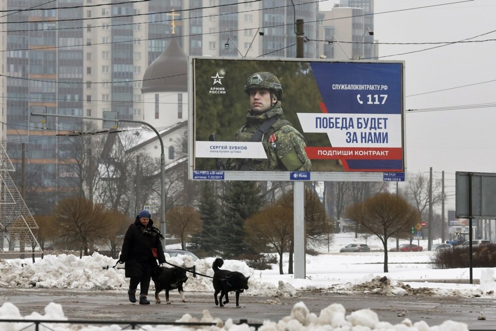 A woman walks past a billboard advertising contract service in St. Petersburg, Russia, 14 January 2025. Photo: EPA-EFE/ANATOLY MALTSEV