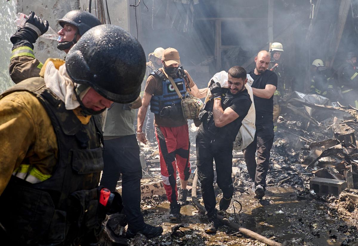 Rescuers remove a dead body from a printing press in Ukraine’s second city Kharkiv following a Russian missile strike on 23 May 2024. Photo: EPA-EFE / SERGEY KOZLOV