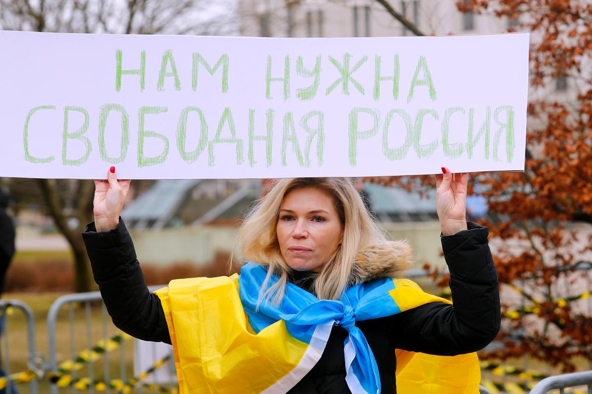 A protester outside the Russian Embassy in Riga, Latvia, holding a sign reading ”We need a free Russia“, 17 March 2024. Photo: EPA-EFE/TOMS KALNINS