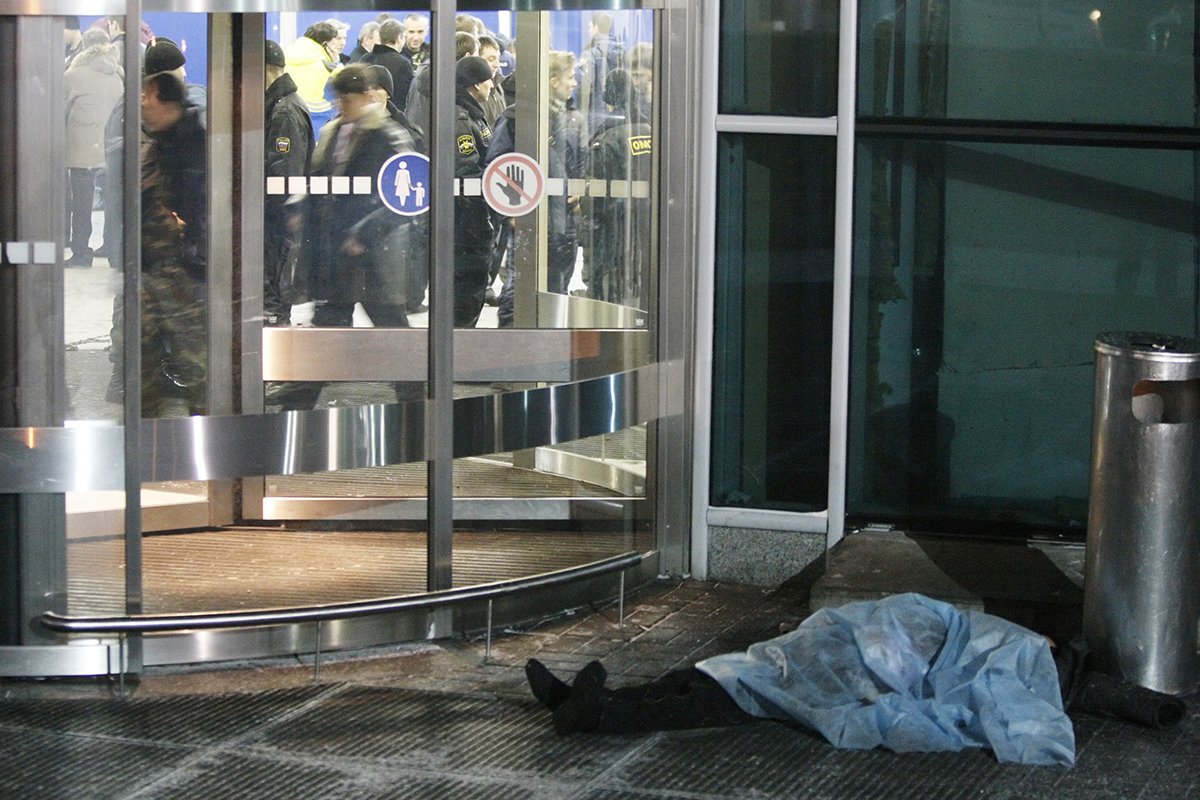 Тело жертвы взрыва бомбы перед входной дверью в аэропорту Домодедово в Москве, Россия, 24 января 2011 года. Фото: Юрий Кочетков/EPA